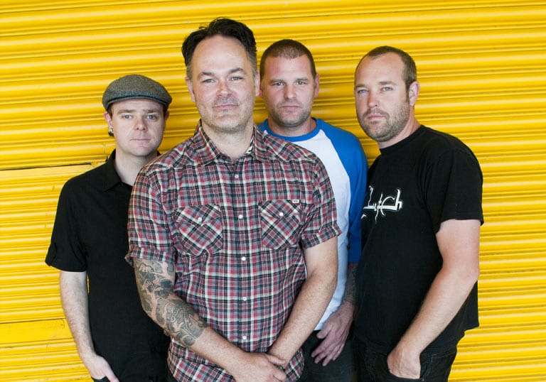 Bodyjar band members standing in front of a yellow roller door