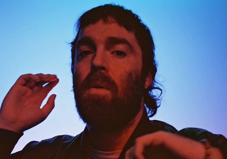 Portrait of Chet Faker with strong blue and red studio lighting