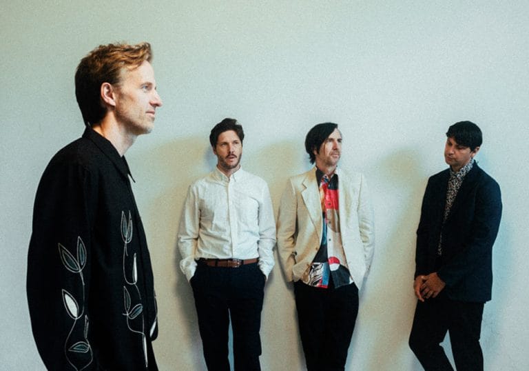 Cut Copy Cut Copy band dressed nice in suits, standing in front of a white background