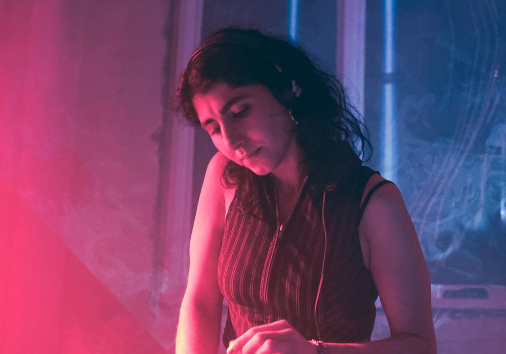 DJ Sarah doing in a room with pink and blue lighting