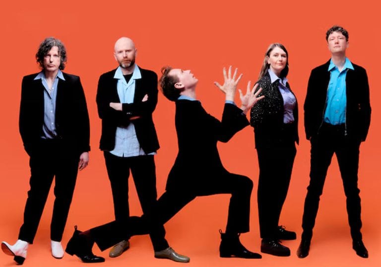 Franz Ferdinand Franz Ferdinand band wearing black suits, posing in front of a bright orange backdrop