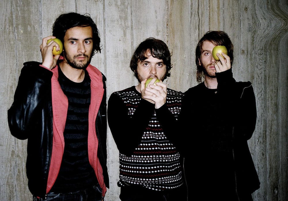 Midnight Juggernauts band holding and eating green apples