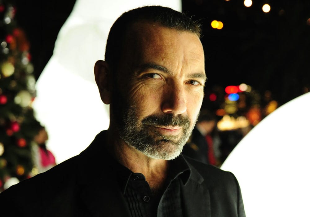 Paul Mac portrait pictured in a room with strong lighting and bokeh lights in the background
