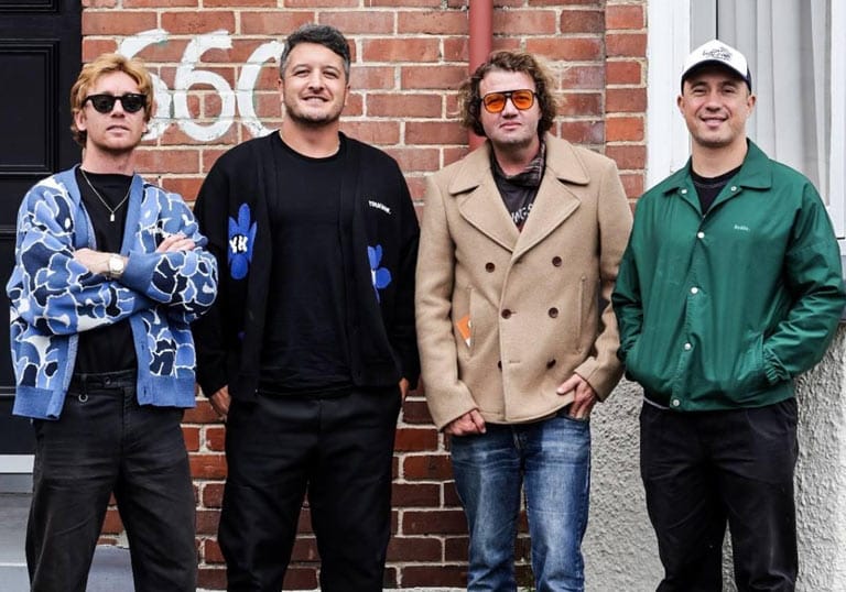 SIX60 band members standing outside of a building that says 660