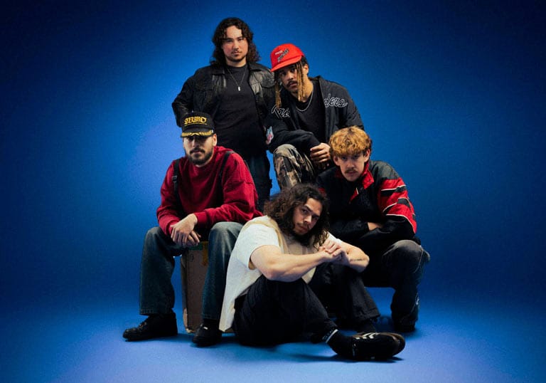 South Summit band members posing in a studio with a blue backdrop