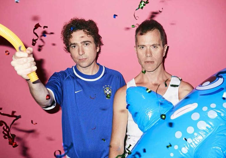 The Presets posing together with confetti against a bright pink background.