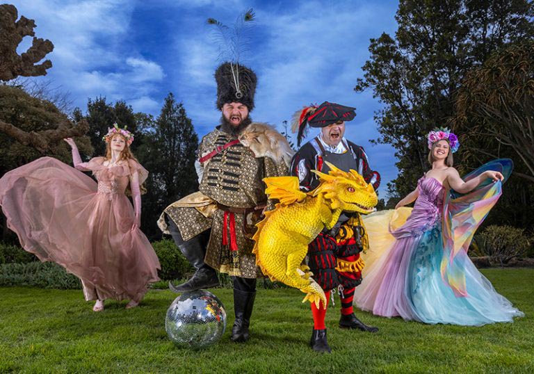 Renfair Rave A whimsical fantasy-themed group portrait outdoors in a garden beneath a vivid blue sky.